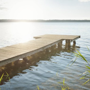 Orman nehri (göl) güneşli bir günde. Ahşap iskele. Clea gökyüzü, kristal berrak suda yansıyor. Idyllic manzara, kırsal manzara. Doğa, ekoloji, eko-turizm, yürüyüş, ekoloji beldesi, yerel turizm