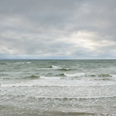 Fırtına sırasında Baltık Denizi. Dramatik gökyüzü, karanlık, parlak bulutlar. Dalgalar, su sıçramaları. Idyllic deniz manzarası. İklim değişikliği, doğa, kararsız hava, ekoloji