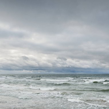 Fırtına sırasında Baltık Denizi. Dramatik gökyüzü, karanlık, parlak bulutlar. Dalgalar, su sıçramaları. Idyllic deniz manzarası. İklim değişikliği, doğa, kararsız hava, ekoloji