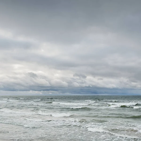 Fırtına sırasında Baltık Denizi. Dramatik gökyüzü, karanlık, parlak bulutlar. Dalgalar, su sıçramaları. Idyllic deniz manzarası. İklim değişikliği, doğa, kararsız hava, ekoloji