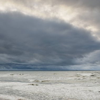 Fırtına sırasında Baltık Denizi. Dramatik gökyüzü, karanlık, parlak bulutlar. Dalgalar, su sıçramaları. Idyllic deniz manzarası. İklim değişikliği, doğa, kararsız hava, ekoloji