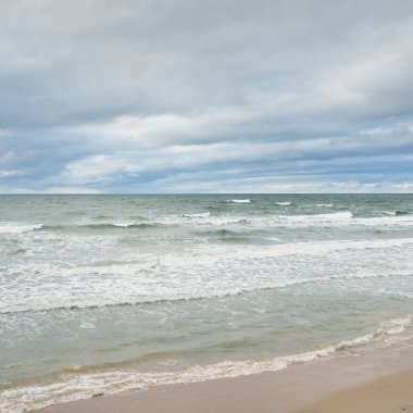 Fırtına sırasında Baltık Denizi. Dramatik gökyüzü, karanlık, parlak bulutlar. Dalgalar, su sıçramaları. Idyllic deniz manzarası. İklim değişikliği, doğa, kararsız hava, ekoloji