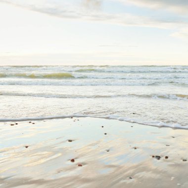 Gün batımında Baltık kıyısı. Açık günbatımı gökyüzü, parlayan bulutlar. Idyllic manzara. Doğa, tatiller, eğlence. Çevre turizmi. Panoramik görünüm
