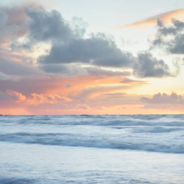 Deniz dalgaları ve sıçrama dokusu. Renkli gökyüzü suya yansıyor. Idyllic deniz manzarası. Kavramsal görüntü, uzun pozlama. Resimli bir manzara var. Arkaplan, duvar kağıdı, doğal desen, grafik kaynakları