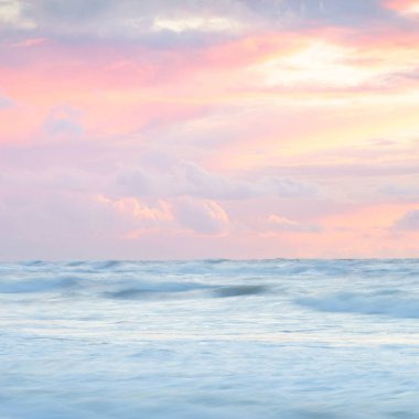 Deniz dalgaları ve sıçrama dokusu. Renkli gökyüzü suya yansıyor. Idyllic deniz manzarası. Kavramsal görüntü, uzun pozlama. Resimli bir manzara var. Arkaplan, duvar kağıdı, doğal desen, grafik kaynakları