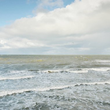 Fırtınadan sonra dramatik günbatımı bulutları altında Baltık Denizi. Dalgalar, su sıçratma. Destansı deniz manzarası. 40-50 deniz mili rüzgar gücü. Kasırga, fırtına, sert hava, meteoroloji, ekoloji, iklim değişikliği