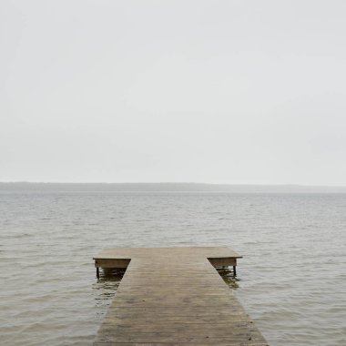 Yoğun bir siste orman nehri (göl). Ahşap iskele. Kasvetli gökyüzü, yağmur. Bulutlu bir gün. Idyllic manzara, kırsal manzara. Doğa, ekoloji, eko-turizm, yürüyüş, ekoloji beldesi, yerel turizm