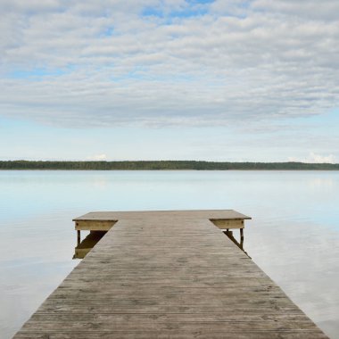 Orman nehri (göl) güneşli bir günde. Ahşap iskele. Clea gökyüzü, kristal berrak suda yansıyor. Idyllic manzara, kırsal manzara. Doğa, ekoloji, eko-turizm, yürüyüş, ekoloji beldesi, yerel turizm