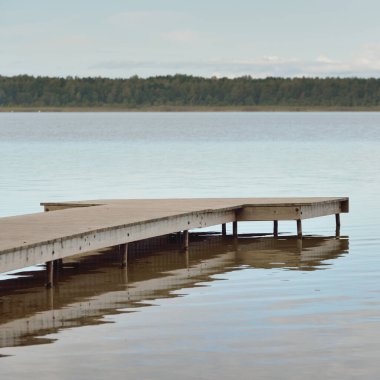 Orman nehri (göl) güneşli bir günde. Ahşap iskele. Clea gökyüzü, kristal berrak suda yansıyor. Idyllic manzara, kırsal manzara. Doğa, ekoloji, eko-turizm, yürüyüş, ekoloji beldesi, yerel turizm