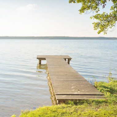 Orman nehri (göl) güneşli bir günde. Ahşap iskele. Clea gökyüzü, kristal berrak suda yansıyor. Idyllic manzara, kırsal manzara. Doğa, ekoloji, eko-turizm, yürüyüş, ekoloji beldesi, yerel turizm