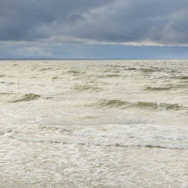 Fırtına sırasında Baltık Denizi. Dramatik gökyüzü, karanlık, parlak bulutlar. Dalgalar, su sıçramaları. Idyllic deniz manzarası. İklim değişikliği, doğa, kararsız hava, ekoloji