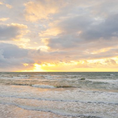 Gün batımında Baltık kıyılarından panoramik manzara. Dramatik bulutlar, parlayan bulutlar, fırtınadan sonra altın güneş ışığı. Doğa, çevre, iklim değişikliği, kararsız hava