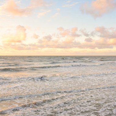 Deniz dalgaları ve sıçrama dokusu. Renkli gökyüzü suya yansıyor. Idyllic deniz manzarası. Kavramsal görüntü, uzun pozlama. Resimli bir manzara var. Arkaplan, duvar kağıdı, doğal desen, grafik kaynakları