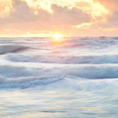 Deniz dalgaları ve sıçrama dokusu. Renkli gökyüzü suya yansıyor. Idyllic deniz manzarası. Kavramsal görüntü, uzun pozlama. Resimli bir manzara var. Arkaplan, duvar kağıdı, doğal desen, grafik kaynakları