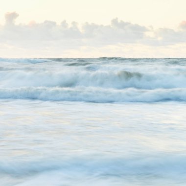 Deniz dalgaları ve sıçrama dokusu. Renkli gökyüzü suya yansıyor. Idyllic deniz manzarası. Kavramsal görüntü, uzun pozlama. Resimli bir manzara var. Arkaplan, duvar kağıdı, doğal desen, grafik kaynakları