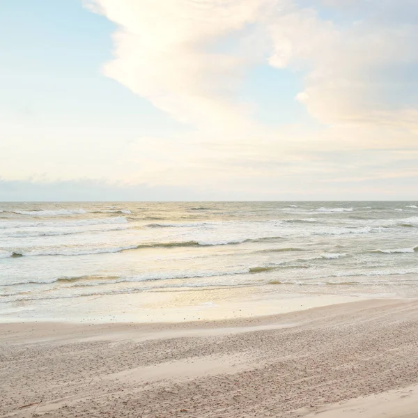 Gün batımında Baltık kıyısı. Açık günbatımı gökyüzü, parlayan bulutlar. Idyllic manzara. Doğa, tatiller, eğlence. Çevre turizmi. Panoramik görünüm