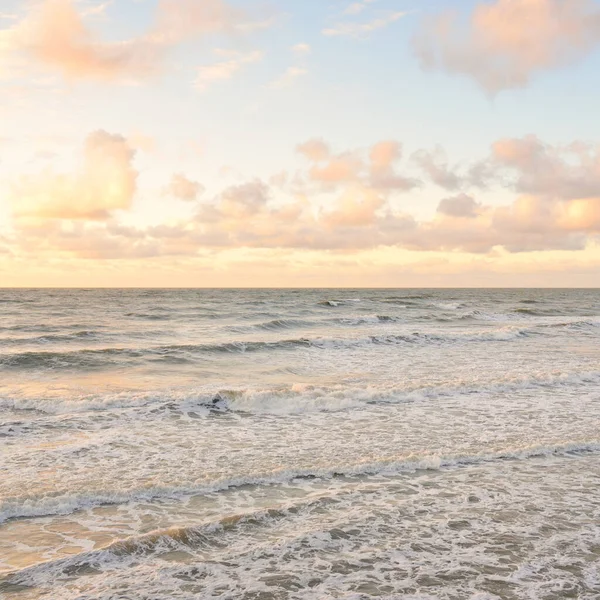 Deniz dalgaları ve sıçrama dokusu. Renkli gökyüzü suya yansıyor. Idyllic deniz manzarası. Kavramsal görüntü, uzun pozlama. Resimli bir manzara var. Arkaplan, duvar kağıdı, doğal desen, grafik kaynakları