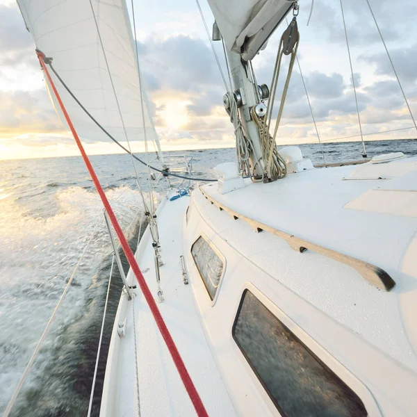 夕日の海でヨットセーリング デッキ マスト 帆の近くの景色 雨の後に澄んだ空 劇的な輝く雲 黄金の太陽の光 波と水のスプラッシュ サイクロン 叙事詩の海景 — ストック写真
