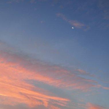 Açık mavi gökyüzü. Pembe ve altın renkli bulutlar. Gün doğumu. Dramatik bulut manzarası. Sanat, meteoroloji, cennet, umut, barış, grafik kaynakları, resimli panoramik manzara