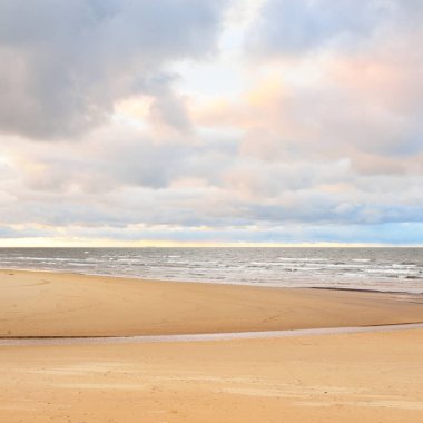Gün batımında Baltık kıyısı. Kumsal manzarası (kum tepeleri). Dramatik günbatımı gökyüzü, parlayan bulutlar. Idyllic manzara. Doğa, tatiller, eğlence. Çevre turizmi. Panoramik görünüm