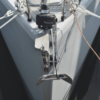 Beyaz modern yelkenli (kiralık ve satılık) yat limanındaki bir rıhtıma demirlemiş. Tahta meşe güvertesi. Denizcilik, ulaşım, amatör yelkencilik, tatiller, gezinti, eğlence kavramları