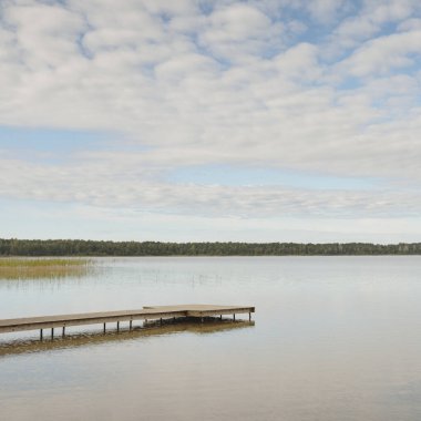 Orman nehri (göl) güneşli bir günde. Ahşap iskele. Clea gökyüzü, kristal berrak suda yansıyor. Idyllic manzara, kırsal manzara. Doğa, ekoloji, eko-turizm, yürüyüş, ekoloji beldesi, yerel turizm