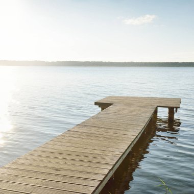 Orman nehri (göl) güneşli bir günde. Ahşap iskele. Clea gökyüzü, kristal berrak suda yansıyor. Idyllic manzara, kırsal manzara. Doğa, ekoloji, eko-turizm, yürüyüş, ekoloji beldesi, yerel turizm