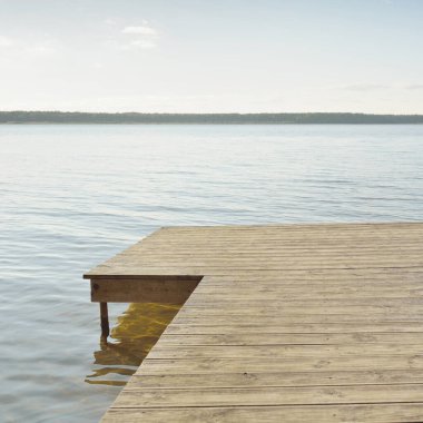Orman nehri (göl) güneşli bir günde. Ahşap iskele. Clea gökyüzü, kristal berrak suda yansıyor. Idyllic manzara, kırsal manzara. Doğa, ekoloji, eko-turizm, yürüyüş, ekoloji beldesi, yerel turizm