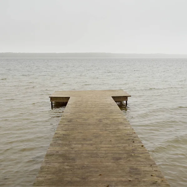Yoğun bir siste orman nehri (göl). Ahşap iskele. Kasvetli gökyüzü, yağmur. Bulutlu bir gün. Idyllic manzara, kırsal manzara. Doğa, ekoloji, eko-turizm, yürüyüş, ekoloji beldesi, yerel turizm