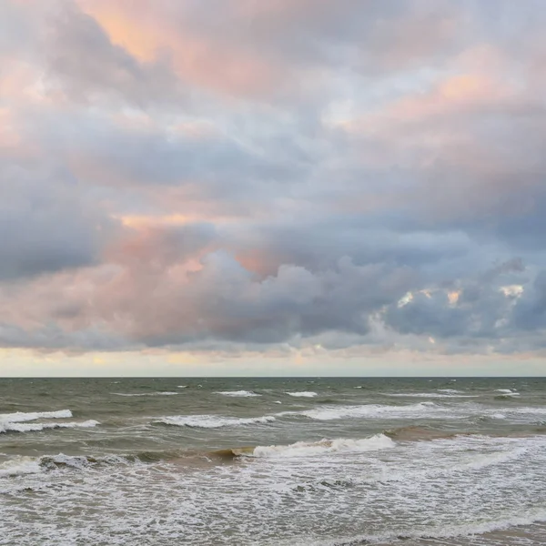 Gün batımında Baltık kıyılarından panoramik manzara. Dramatik bulutlar, parlayan bulutlar, fırtınadan sonra altın güneş ışığı. Doğa, çevre, iklim değişikliği, kararsız hava