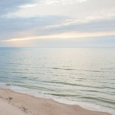 Gün batımında Baltık kıyılarından panoramik hava manzarası. Dramatik bulutlar, parlayan bulutlar, fırtınadan sonra altın güneş ışığı. Doğa, çevre, iklim değişikliği, kararsız hava
