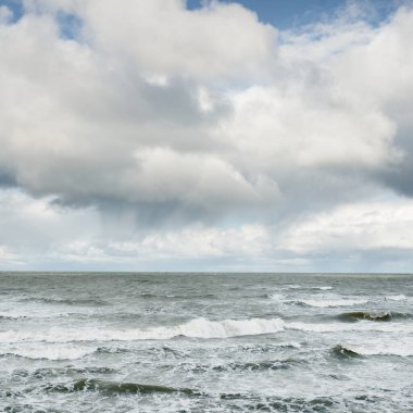 Fırtınadan sonra dramatik günbatımı bulutları altında Baltık Denizi. Dalgalar, su sıçratma. Destansı deniz manzarası. 40-50 deniz mili rüzgar gücü. Kasırga, fırtına, sert hava, meteoroloji, ekoloji, iklim değişikliği