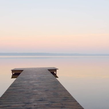 Forest lake (river) at sunrise. Wooden pier (boardwalk). Soft sunlight, mist, reflections on water. Idyllic autumn landscape. Pure nature, ecotourism, hiking, exploring