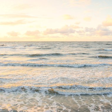 Deniz dalgaları ve sıçrama dokusu. Renkli gökyüzü suya yansıyor. Idyllic deniz manzarası. Kavramsal görüntü, uzun pozlama. Resimli bir manzara var. Arkaplan, duvar kağıdı, doğal desen, grafik kaynakları