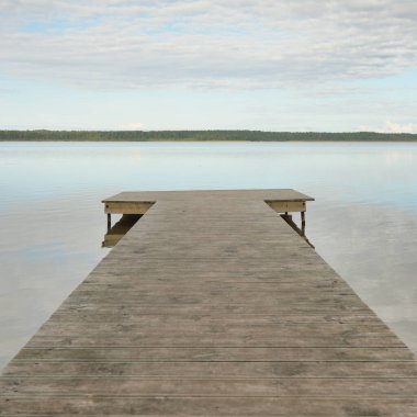 Orman nehri (göl) güneşli bir günde. Ahşap iskele. Clea gökyüzü, kristal berrak suda yansıyor. Idyllic manzara, kırsal manzara. Doğa, ekoloji, eko-turizm, yürüyüş, ekoloji beldesi, yerel turizm