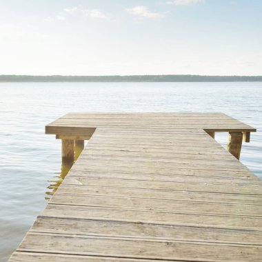 Orman nehri (göl) güneşli bir günde. Ahşap iskele. Clea gökyüzü, kristal berrak suda yansıyor. Idyllic manzara, kırsal manzara. Doğa, ekoloji, eko-turizm, yürüyüş, ekoloji beldesi, yerel turizm