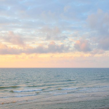 Gün batımında Baltık kıyılarından panoramik manzara. Dramatik bulutlar, parlayan bulutlar, fırtınadan sonra altın güneş ışığı. Doğa, çevre, iklim değişikliği, kararsız hava