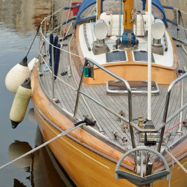 Modern klasik ahşap İsveçli yelkenli teknesi yat limanındaki bir iskeleye demirlemiş. Turizm, tatiller, boş zaman aktiviteleri, eğlence, yelkencilik temaları