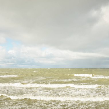 Fırtınadan sonra dramatik günbatımı bulutları altında Baltık Denizi. Dalgalar, su sıçratma. Destansı deniz manzarası. 40-50 deniz mili rüzgar gücü. Kasırga, fırtına, sert hava, meteoroloji, ekoloji, iklim değişikliği