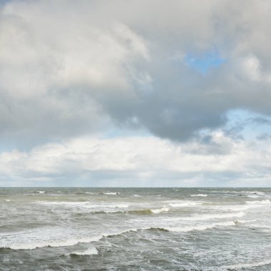 Fırtınadan sonra dramatik günbatımı bulutları altında Baltık Denizi. Dalgalar, su sıçratma. Destansı deniz manzarası. Kasırga, fırtına, sert hava, meteoroloji, ekoloji, iklim değişikliği, doğal olaylar