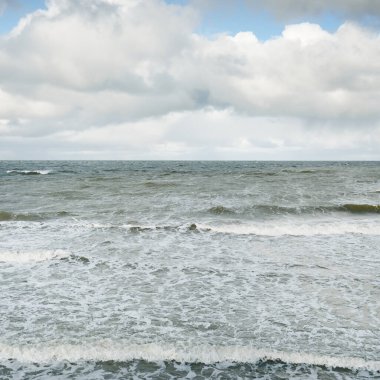 Fırtınadan sonra dramatik günbatımı bulutları altında Baltık Denizi. Dalgalar, su sıçratma. Destansı deniz manzarası. 40-50 deniz mili rüzgar gücü. Kasırga, fırtına, sert hava, meteoroloji, ekoloji, iklim değişikliği