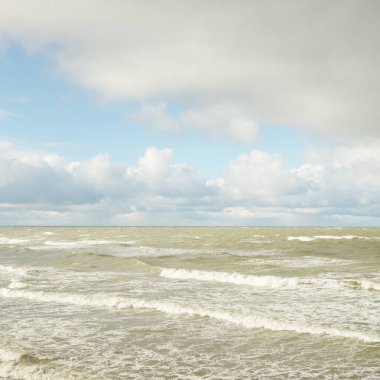 Fırtınadan sonra dramatik günbatımı bulutları altında Baltık Denizi. Dalgalar, su sıçratma. Destansı deniz manzarası. 40-50 deniz mili rüzgar gücü. Kasırga, fırtına, sert hava, meteoroloji, ekoloji, iklim değişikliği