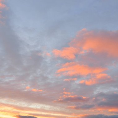 Parlayan pembe, altın rengi sirrus ve kümülüs bulutlarıyla açık mavi gökyüzü. Gün doğumu. Dramatik bulut manzarası. Sanat, meteoroloji, cennet, umut, barış, grafik kaynakları, resimli panoramik manzara