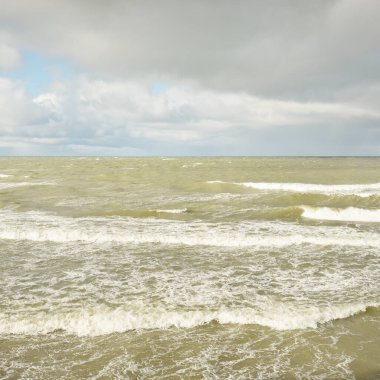 Fırtınadan sonra dramatik günbatımı bulutları altında Baltık Denizi. Dalgalar, su sıçratma. Destansı deniz manzarası. Kasırga, fırtına, sert hava, meteoroloji, ekoloji, iklim değişikliği, doğal olaylar