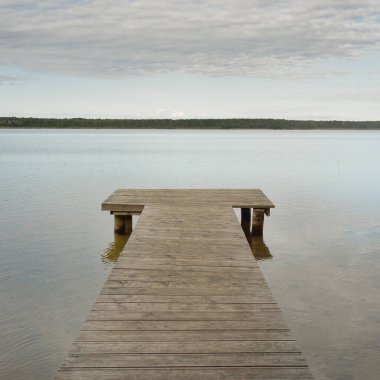 Orman nehri (göl) güneşli bir günde. Ahşap iskele. Clea gökyüzü, kristal berrak suda yansıyor. Idyllic manzara, kırsal manzara. Doğa, ekoloji, eko-turizm, yürüyüş, ekoloji beldesi, yerel turizm