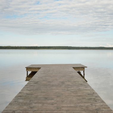 Orman nehri (göl) güneşli bir günde. Ahşap iskele. Clea gökyüzü, kristal berrak suda yansıyor. Idyllic manzara, kırsal manzara. Doğa, ekoloji, eko-turizm, yürüyüş, ekoloji beldesi, yerel turizm