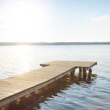 Orman nehri (göl) güneşli bir günde. Ahşap iskele. Clea gökyüzü, kristal berrak suda yansıyor. Idyllic manzara, kırsal manzara. Doğa, ekoloji, eko-turizm, yürüyüş, ekoloji beldesi, yerel turizm