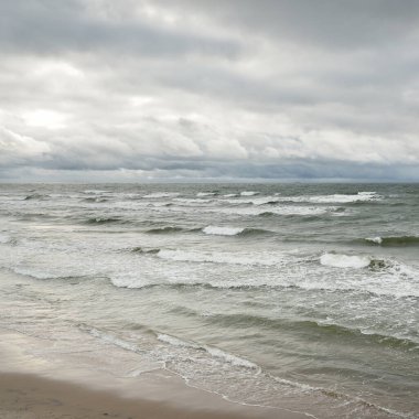 Fırtına sırasında Baltık Denizi. Dramatik gökyüzü, karanlık, parlak bulutlar. Dalgalar, su sıçramaları. Idyllic deniz manzarası. İklim değişikliği, doğa, kararsız hava, ekoloji