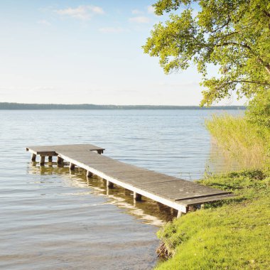 Orman nehri (göl) güneşli bir günde. Ahşap iskele. Clea gökyüzü, kristal berrak suda yansıyor. Idyllic manzara, kırsal manzara. Doğa, ekoloji, eko-turizm, yürüyüş, ekoloji beldesi, yerel turizm