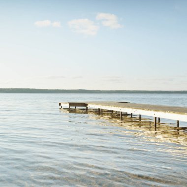 Orman nehri (göl) güneşli bir günde. Ahşap iskele. Clea gökyüzü, kristal berrak suda yansıyor. Idyllic manzara, kırsal manzara. Doğa, ekoloji, eko-turizm, yürüyüş, ekoloji beldesi, yerel turizm